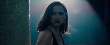 Movie still from “No Time to Die” (2021), directed by Cary Joji Fukunaga – A beautiful woman with dark brown hair wearing a black dress; Close Up shot, Low angle