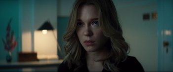 Movie still from “No Time to Die” (2021), directed by Cary Joji Fukunaga – A beautiful young woman with long blonde hair and blue eyes; Close Up shot, Over the shoulder angle