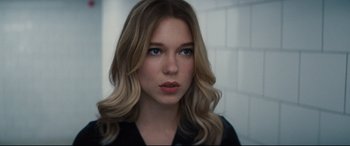 Movie still from “No Time to Die” (2021), directed by Cary Joji Fukunaga – A beautiful young woman with long blonde hair and blue eyes; Close Up shot, Over the shoulder angle