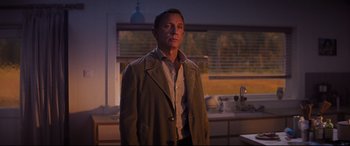 Movie still from “No Time to Die” (2021), directed by Cary Joji Fukunaga – A man standing in a kitchen in front of a sink; Medium shot, Low angle