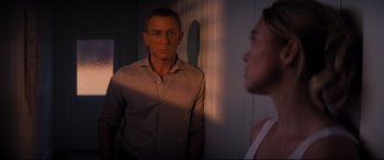 Movie still from “No Time to Die” (2021), directed by Cary Joji Fukunaga – A man and a woman looking at one another in a room; Medium shot, Over the shoulder angle