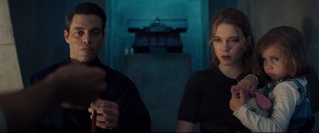 Movie still from “No Time to Die” (2021), directed by Cary Joji Fukunaga – A man and a woman sitting next to each other in a room; Medium shot, Over the shoulder angle