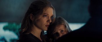 Movie still from “No Time to Die” (2021), directed by Cary Joji Fukunaga – A woman and a child looking at the camera; Close Up shot, Over the shoulder angle