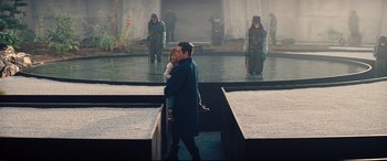 Movie still from “No Time to Die” (2021), directed by Cary Joji Fukunaga – A man and a woman kissing in front of a fountain; Wide shot, High angle