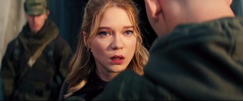 Movie still from “No Time to Die” (2021), directed by Cary Joji Fukunaga – A woman looking at a man in a green jacket; Close Up shot, Over the shoulder angle