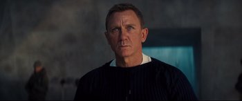 Movie still from “No Time to Die” (2021), directed by Cary Joji Fukunaga – A person wearing a sweater; Close Up shot, Over the shoulder angle