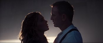 Movie still from “No Time to Die” (2021), directed by Cary Joji Fukunaga – A man and a woman face to face in the dark; Close Up shot, Low angle