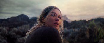 Movie still from “No Time to Die” (2021), directed by Cary Joji Fukunaga – A person with long blonde hair; Close Up shot, Low angle