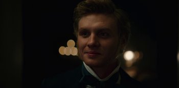 Movie still from “The Empress” (2022), created by Katharina Eyssen – A person wearing a suit and bow tie; Close Up shot, Over the shoulder angle