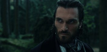 Movie still from “The Empress” (2022), created by Katharina Eyssen – A person wearing a suit and tie; Close Up shot, Low angle