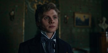 Movie still from “The Empress” (2022), created by Katharina Eyssen – A man in a suit and tie standing in front of a mirror; Close Up shot, Over the shoulder angle