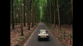 Movie still from “The End of the F***ing World” (2017), directed by Jonathan Entwistle – A car driving down a tree - lined street; Extreme Wide shot, High angle