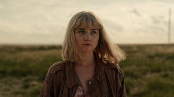 Movie still from “The End of the F***ing World” (2017), directed by Jonathan Entwistle – A woman standing in a grassy field with her hair blowing in the wind; Close Up shot, Low angle