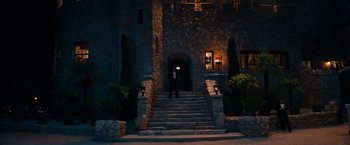 Movie still from “Babylon” (2022), directed by Damien Chazelle – A man standing in front of a stone building; Extreme Wide shot, High angle