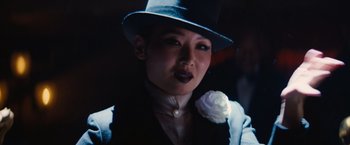 Movie still from “Babylon” (2022), directed by Damien Chazelle – A woman wearing a top hat and a black suit jacket; Close Up shot, Low angle