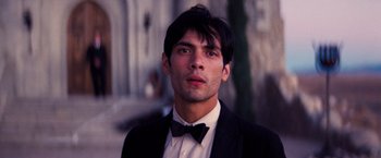 Movie still from “Babylon” (2022), directed by Damien Chazelle – A man wearing a suit and bow tie; Close Up shot, Low angle