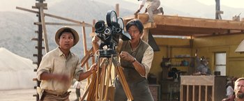 Movie still from “Babylon” (2022), directed by Damien Chazelle – Two men working on a movie camera; Medium shot, Low angle