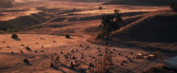 Movie still from “Babylon” (2022), directed by Damien Chazelle – An aerial view of an open field in the middle of the day; Extreme Wide shot, High angle