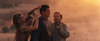 Movie still from “Babylon” (2022), directed by Damien Chazelle – Two men and a woman looking at something on a cell phone; Medium shot, Over the shoulder angle