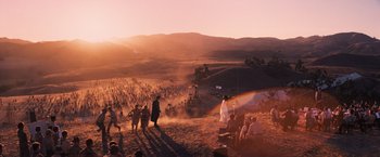 Movie still from “Babylon” (2022), directed by Damien Chazelle – A group of people standing on top of a sandy hill; Extreme Wide shot, High angle