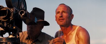 Movie still from “Babylon” (2022), directed by Damien Chazelle – A man and a man in a hat looking up; Close Up shot, Low angle