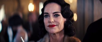Movie still from “Babylon” (2022), directed by Damien Chazelle – An older woman wearing a fur coat and red lipstick; Close Up shot, Over the shoulder angle