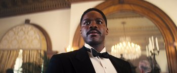 Movie still from “Babylon” (2022), directed by Damien Chazelle – A man wearing a tuxedo and a bow tie; Close Up shot, Low angle
