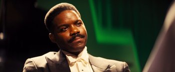 Movie still from “Babylon” (2022), directed by Damien Chazelle – A man in a white shirt and a gray suit; Close Up shot, Low angle