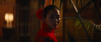 Movie still from “Babylon” (2022), directed by Damien Chazelle – A woman in a red dress with a flower in her hair; Close Up shot, Over the shoulder angle