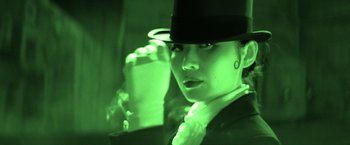 Movie still from “Babylon” (2022), directed by Damien Chazelle – A woman wearing a top hat and holding a drink; Close Up shot, Low angle