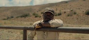 Movie still from “Nope” (2022), directed by Jordan Peele – A man leaning on a metal rail in a field; Close Up shot, Over the shoulder angle
