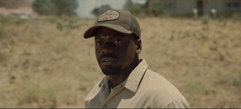 Movie still from “Nope” (2022), directed by Jordan Peele – A man wearing a hat in the middle of the desert; Close Up shot, Over the shoulder angle
