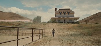 Movie still from “Nope” (2022), directed by Jordan Peele – A man walking down a dirt path in front of a house; Extreme Wide shot, Low angle
