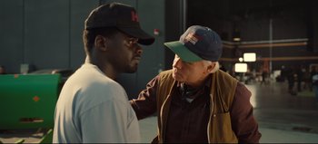 Movie still from “Nope” (2022), directed by Jordan Peele – A man in a baseball cap is talking to another man in a baseball cap; Close Up shot, Over the shoulder angle