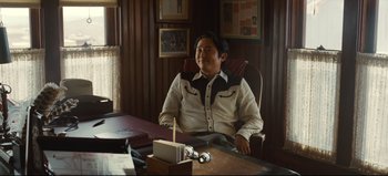 Movie still from “Nope” (2022), directed by Jordan Peele – A man sitting at a desk in a room; Medium shot, Over the shoulder angle