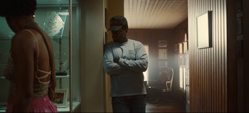 Movie still from “Nope” (2022), directed by Jordan Peele – A man standing in front of a wall with his arms crossed; Medium shot, Low angle