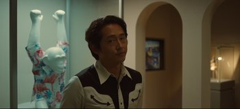 Movie still from “Nope” (2022), directed by Jordan Peele – A man in a black and white shirt looking to his left; Medium shot, Over the shoulder angle