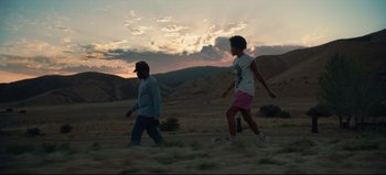 Movie still from “Nope” (2022), directed by Jordan Peele – A couple of people that are walking in the grass; Wide shot, Low angle