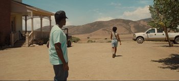 Movie still from “Nope” (2022), directed by Jordan Peele – A man and a woman are standing in the dirt; Wide shot, Over the shoulder angle