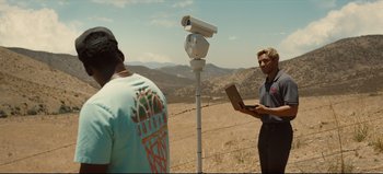 Movie still from “Nope” (2022), directed by Jordan Peele – A man standing next to another man holding a laptop; Medium shot, Low angle