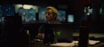 Movie still from “Nope” (2022), directed by Jordan Peele – A man sitting in front of a laptop computer; Medium shot, Over the shoulder angle