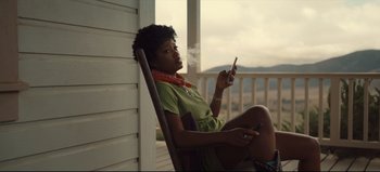 Movie still from “Nope” (2022), directed by Jordan Peele – A woman sitting in a chair with a cell phone in her hand; Medium shot, Low angle