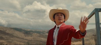 Movie still from “Nope” (2022), directed by Jordan Peele – A man wearing a cowboy hat and a red jacket; Medium shot, Low angle