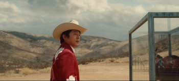 Movie still from “Nope” (2022), directed by Jordan Peele – A man wearing a cowboy hat standing in the desert; Medium shot, Over the shoulder angle