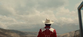 Movie still from “Nope” (2022), directed by Jordan Peele – A man wearing a cowboy hat standing on top of a hill; Extreme Wide shot, Low angle