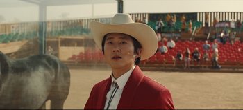 Movie still from “Nope” (2022), directed by Jordan Peele – A man wearing a cowboy hat in front of an audience; Close Up shot, Over the shoulder angle