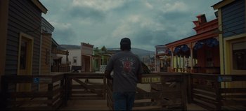 Movie still from “Nope” (2022), directed by Jordan Peele – A man standing in front of a wooden fence; Wide shot, Low angle