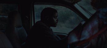 Movie still from “Nope” (2022), directed by Jordan Peele – A man sitting in the driver's seat of a car; Close Up shot, High angle