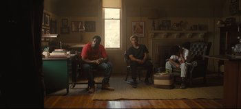 Movie still from “Nope” (2022), directed by Jordan Peele – Two men sitting in a living room next to a fireplace; Wide shot, Low angle
