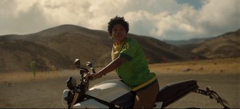Movie still from “Nope” (2022), directed by Jordan Peele – A young man riding a motorcycle on top of a dirt road; Medium shot, Low angle